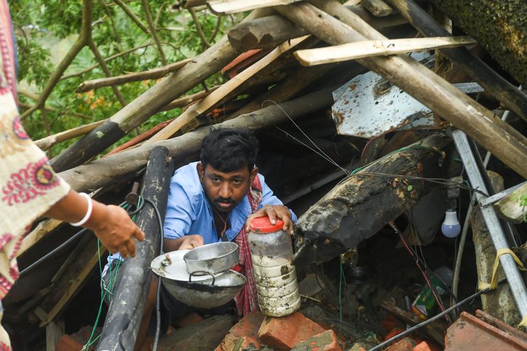 Pere päästmas Indias Lääne-Bengalis Midnapore'is tsüklon Amphani tormi lõhutud majast esemeid.