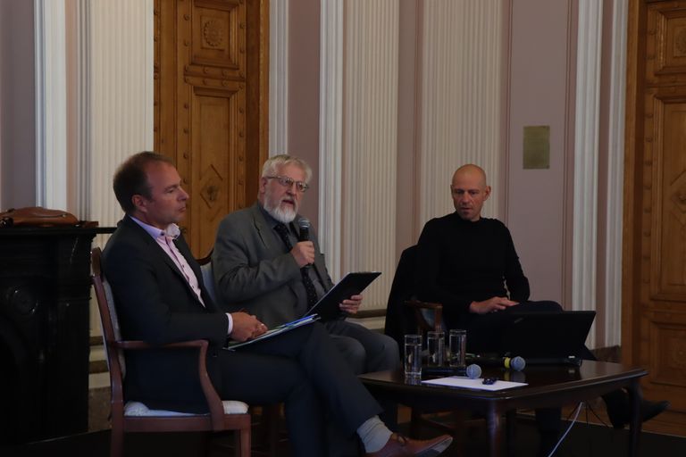 Hando Sutter ja Taavi Veskimägi Teaduste Akadeemias toimuval debatil. Debatti juhib Eesti Teaduste akadeemia president Tarmo Soomere.