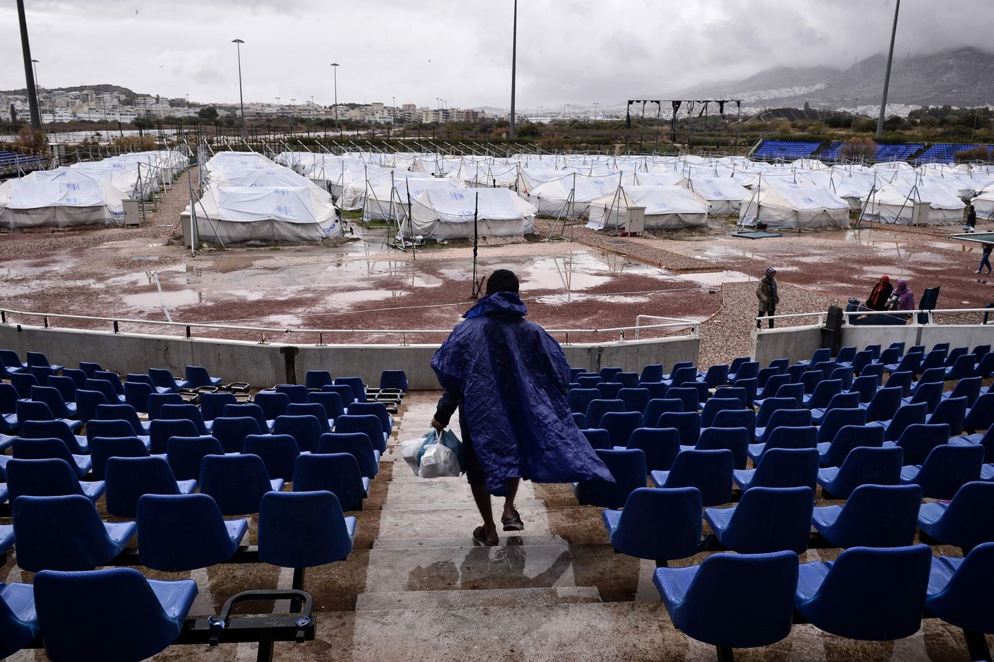 Hellinikoni pesapalliväljak, Ateena, Kreeka. Mitte väga pikka aega tagasi oli väljakumuru kaunilt roheline, toolid erksinised, kuid pärast 2004. aasta olümpiamänge on see lagunenud ja muutunud järjekordseks Kreeka varemeks. 2017. aastal löödi väljakule püsti põgenikelaager.