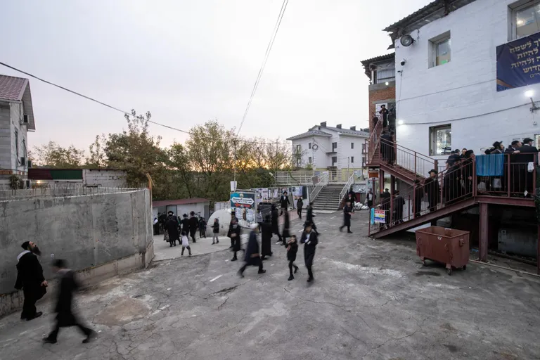Евреи, собравшиеся со всего мира, едут в синагогу в еврейском квартале в Умани на утреннюю молитву. Чтобы вместить всех желающих, зал синагоги занимает два этажа.