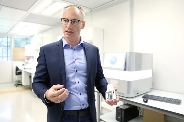 Kaarel Krjutškov hoiab näppude vahel konteinerit, kuhu mahub peale 32 inimese DNA.