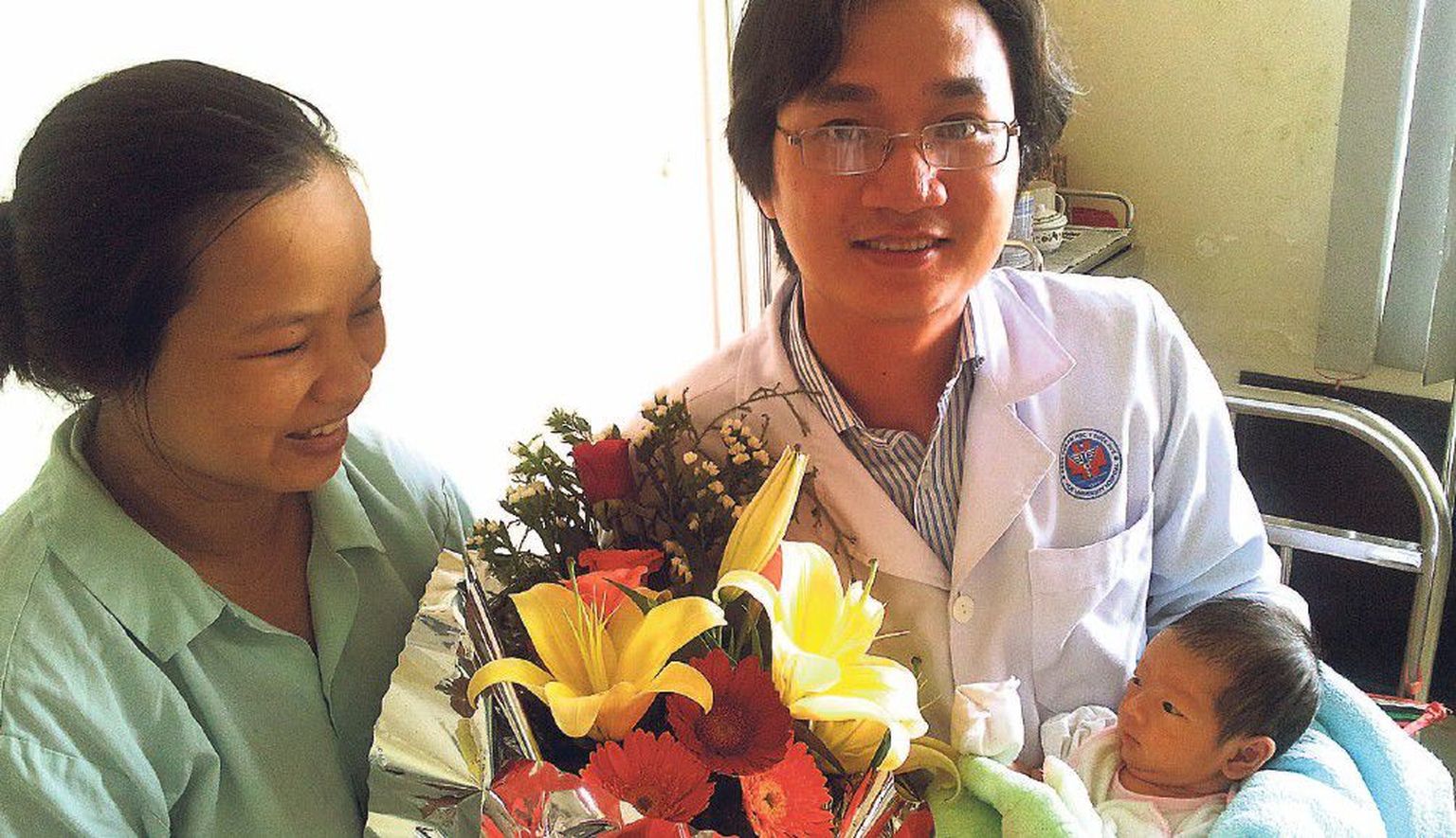 Kesk-Vietnami esimene katseklaasibeebi koos ema ja last ilmale aidanud Hue ülikooli arsti Le Minh Tamiga (paremal).