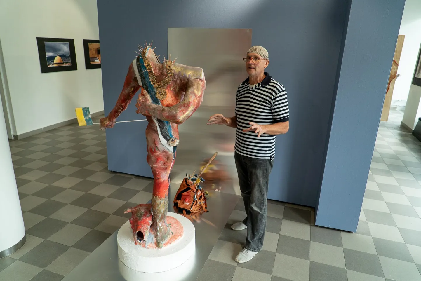 Installatiivse skulptuuri «Aedniku saabumine piirilinna» kõrval jagab seletusi selle autor, skulptor Ahti Seppet. Vasakul on seinal näha fotosid, mille ta on pildistanud välismaa muuseumides.
