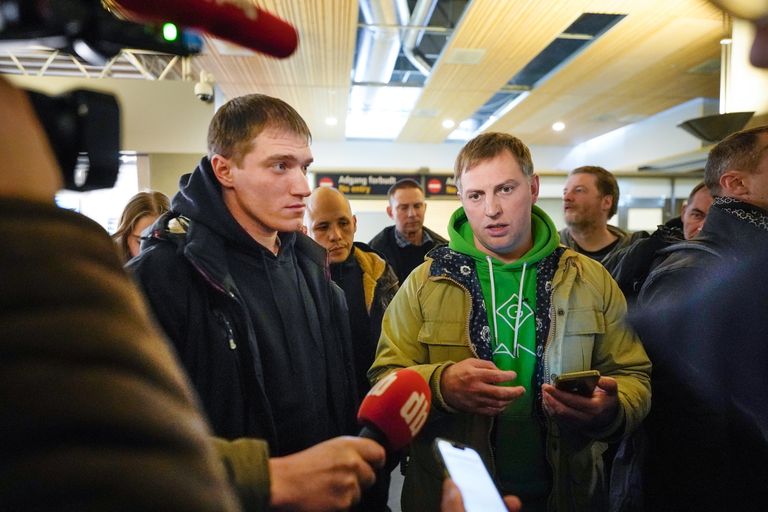 Наемник ЧВК "Вагнер" Андрей Медведев и правозащитник Владимир Осечкин общаются с журналистами в аэропорту, Норвегия, февраль 2023 года.