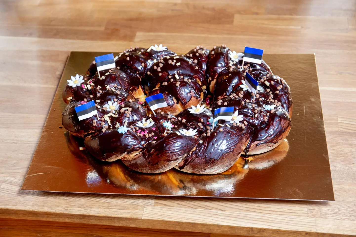 Lilleõite ja sinimustvalgete lipukestega ehitud kringel.