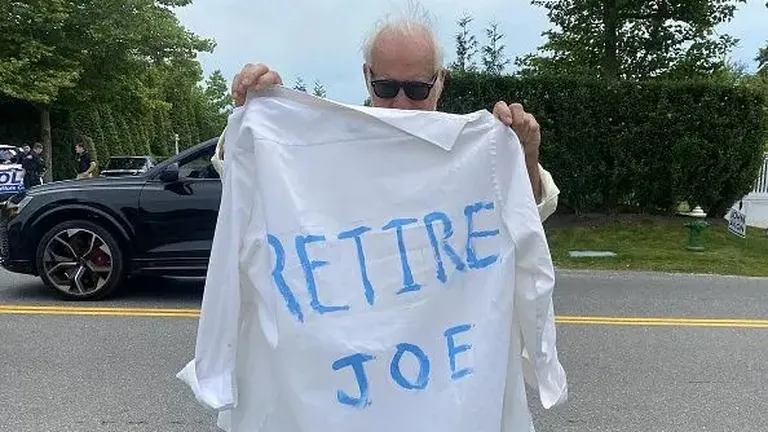 Человек с рубашкой, на которой написано «Выйди на пенсию, Джо».
