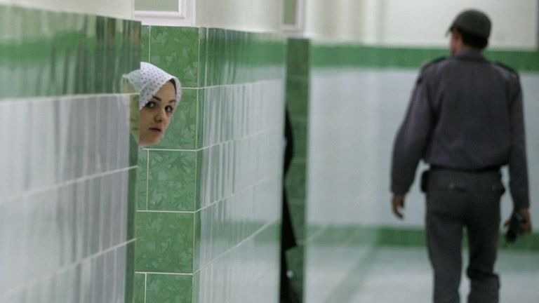 Заключенная выглядывает из-за стены в женском отделении печально известной в Иране тюрьмы Эвин. Многие семьи обрывают связь с женщиной, попавшей под арест, говорят иранские правозащитники.