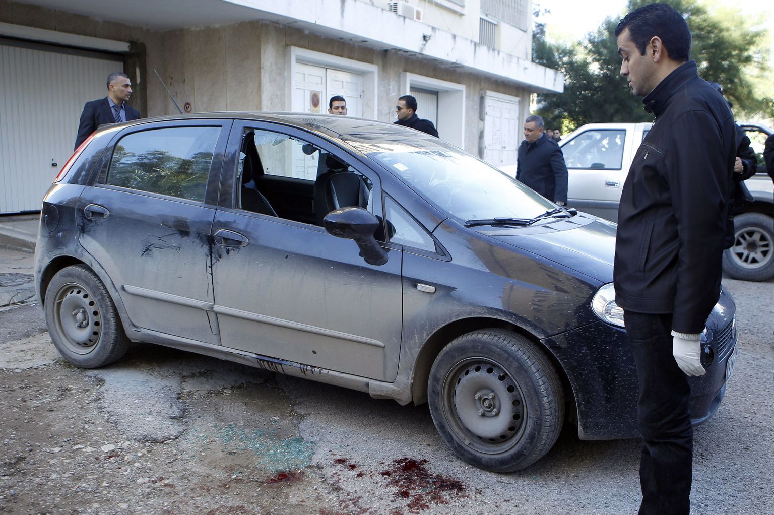 Tuneesia kohtumeditsiini ekspert vaatab opositsionääri Shokri Belaidi verist autot Tunises.