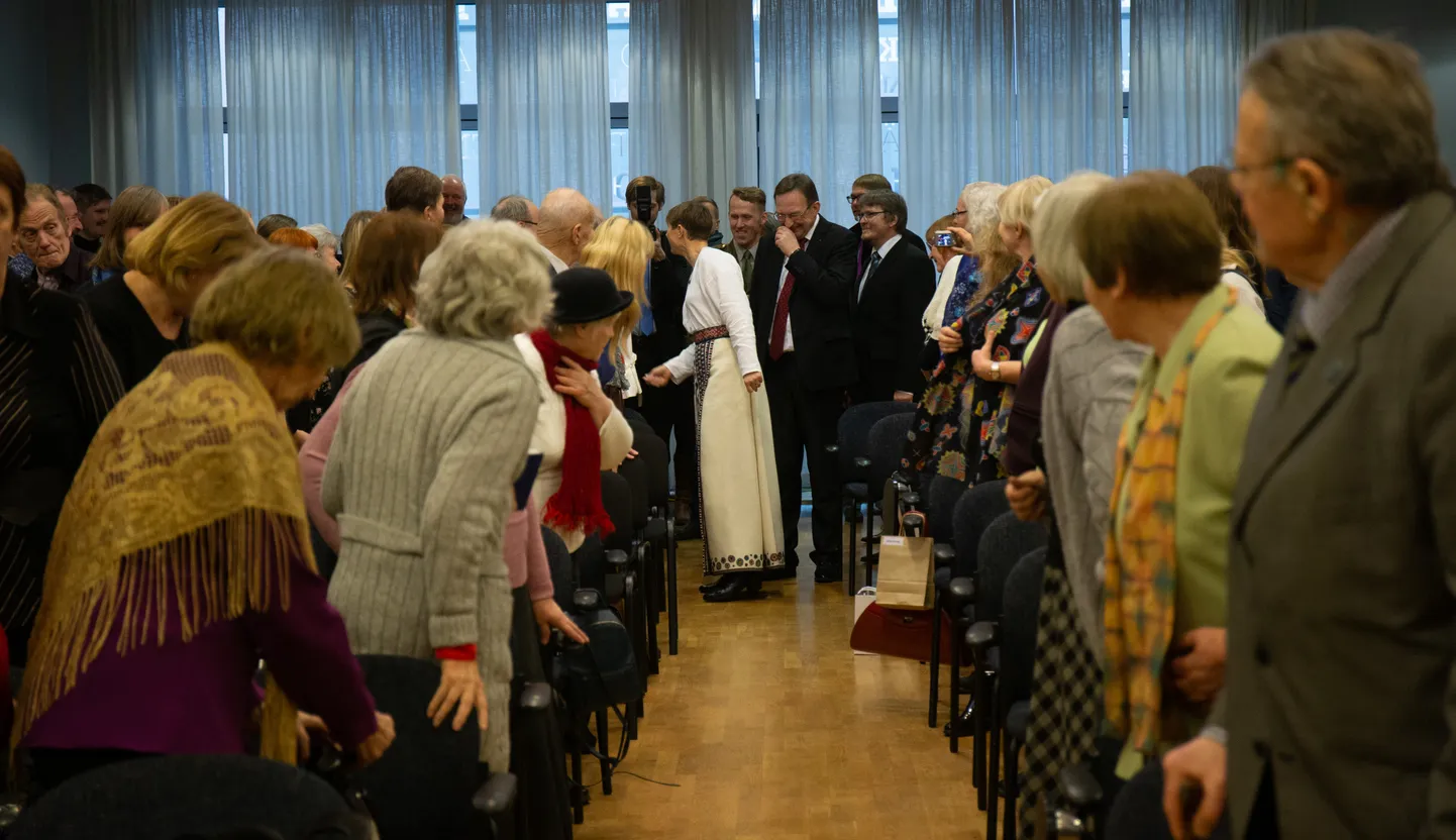 President Kersti Kaljulaidi peatas  Eesti Kirjandusmuuseumi saali sisenedes tartlane Jaan Muna (jääb peitu inimeste taha) oma tervitusmonoloogiga, mille peale president sõnas, et mis võib paremat olla elusast rahvaluulest.