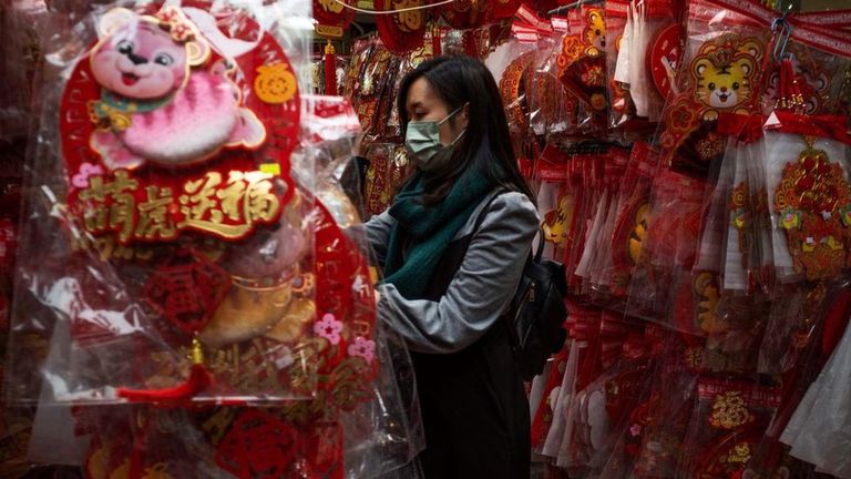 Женщина покупает новогодние украшения в Китае