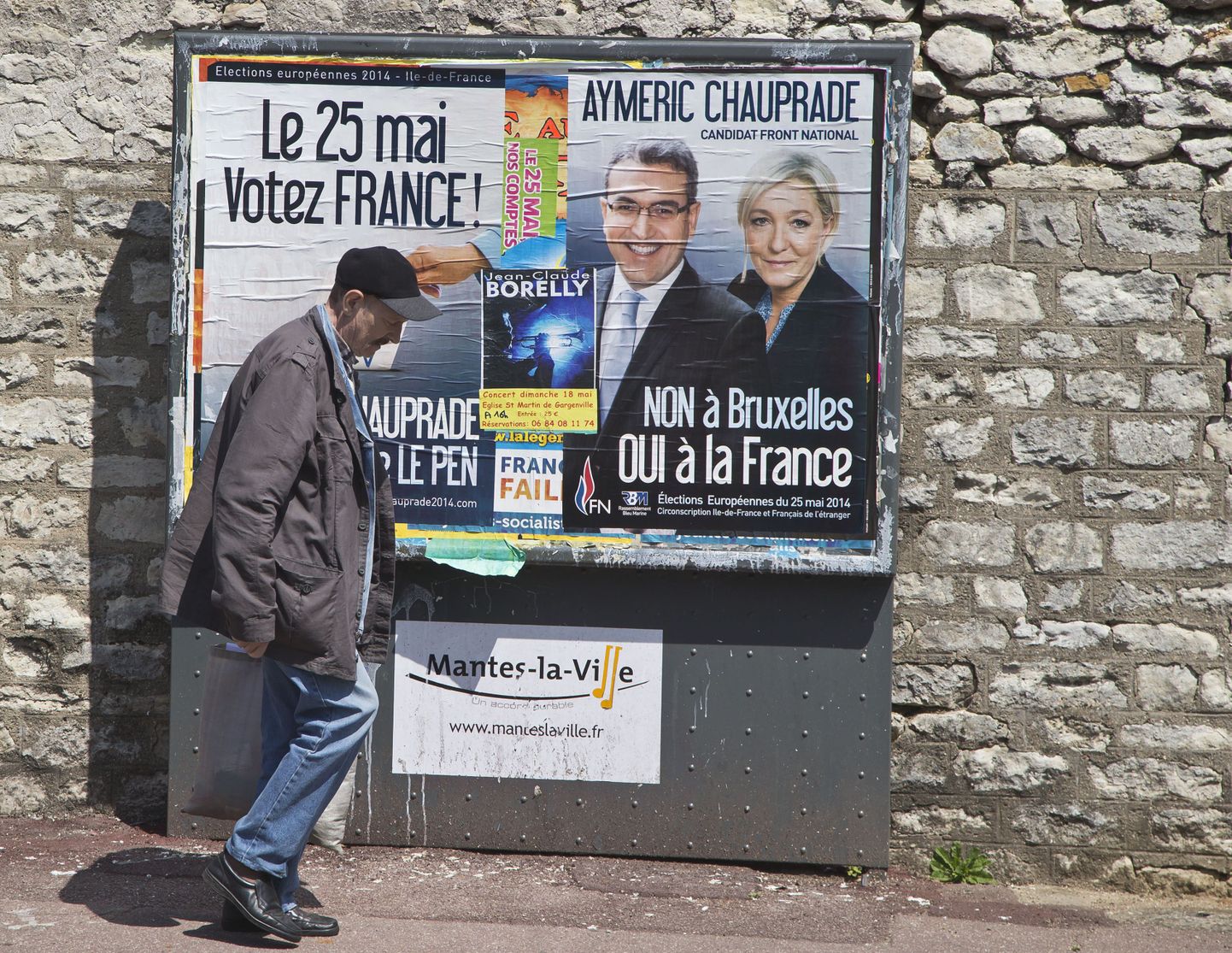 Mantes-la-Ville'i elanik Prantsusmaa Rahvusrinde valimisplakatist mööda kõndimas.