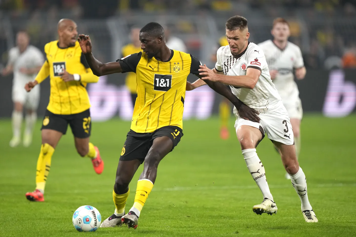 St. Pauli keskkaitsja Karol Mets (paremal) proovib takistada Dortmundi Borussia ründajat Serhou Guirassyt. Guinealane lõi 83. minutil Borussiale 2:1 võidu toonud värava, mis oli talle sel hooajal klubisärgis juba seitsmendaks tabamuseks.