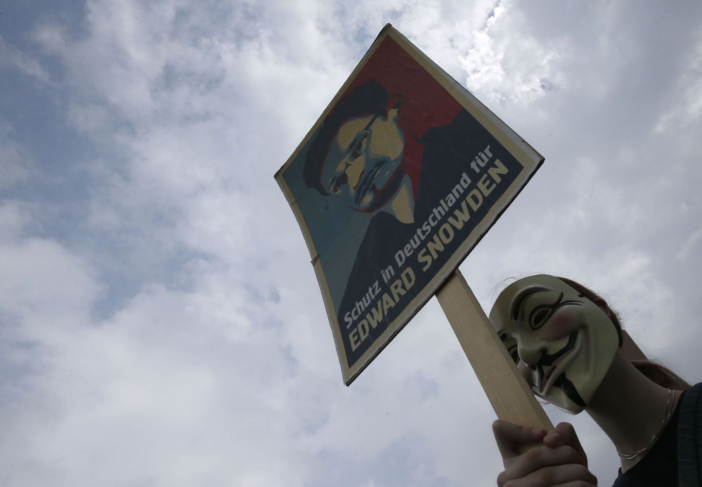 Guy Fawkesi maskiga isik hoiab plakatit, millel on Edward Snowdeni pilt