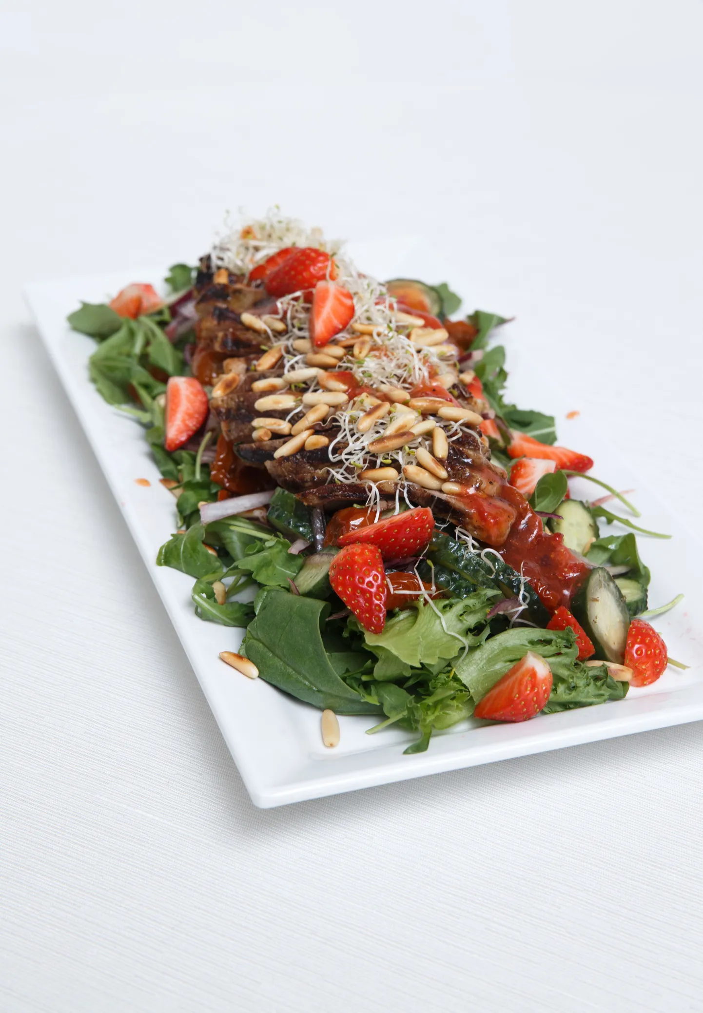Värske salat sealiha ja maasikakastmega.