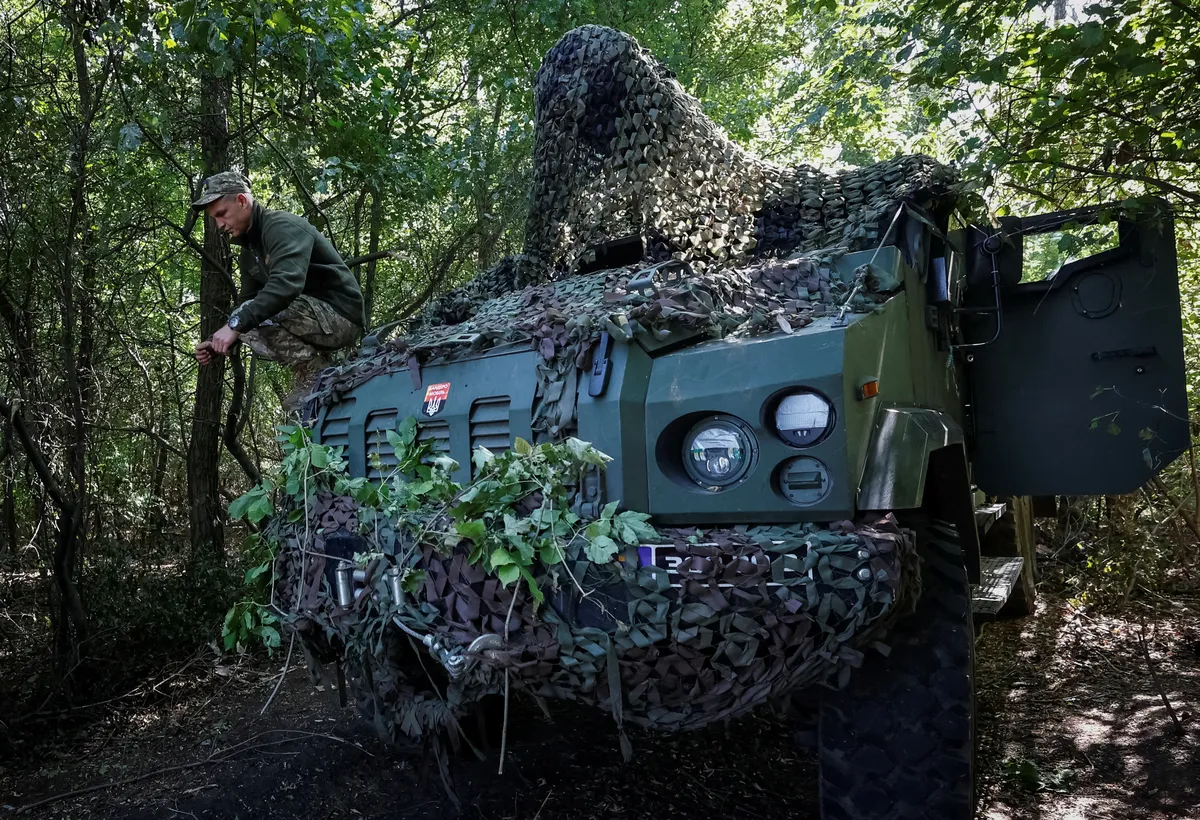 A Ukrainian serviceman squats on a Ukrainian produced 2S22 Bohdana self-propelled howitzer, amid Russia's attack on Ukraine, at a position in Donetsk region, Ukraine. September 13, 2023.
