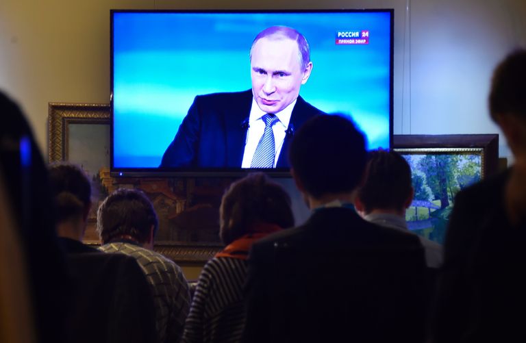 Inimesed vaatavad televiisorist Venemaa presidendi Vladimir Putini kõnet. Foto: Scanpix