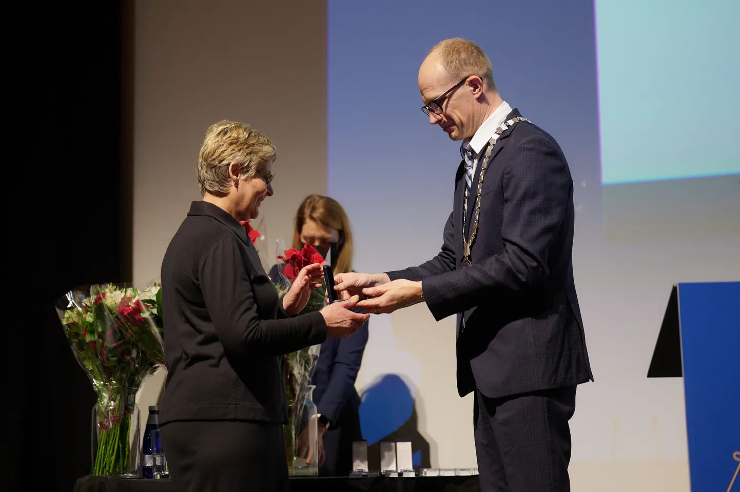 vandeadvokaat Liina Linsi saamas teenetemedalit advokatuuri esimees Jaanus Tehverilt.