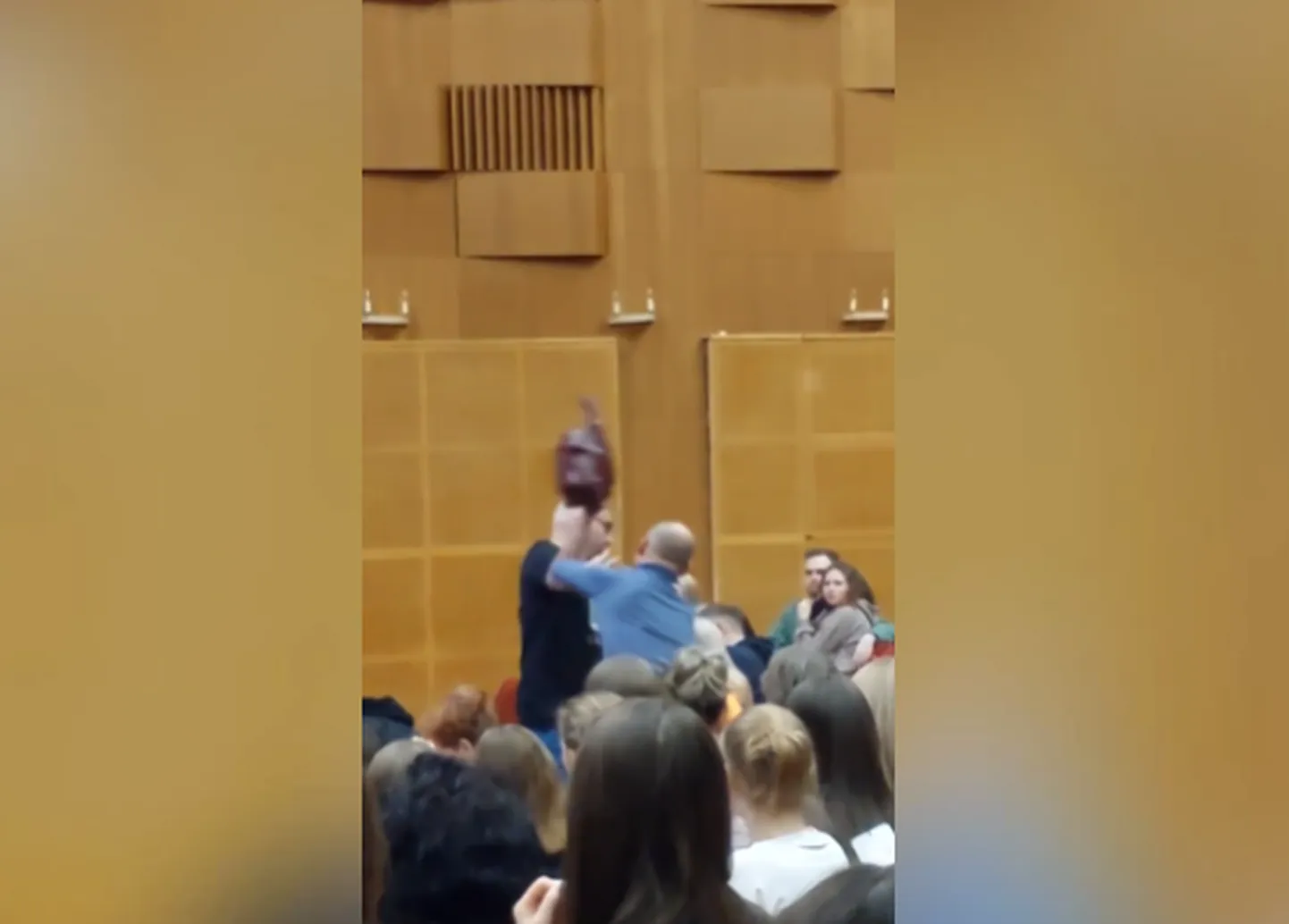 Скриншот, где психолог бьет сумкой слушательницу семинара.