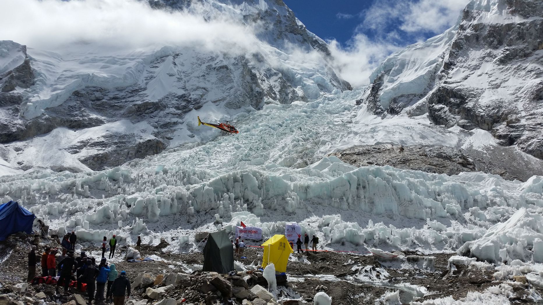 Everesti maratoni stardiala Khumbu liustiku servas baaslaagris. Keskel telkides asusid maratoonarite välikemmergud, nende taga paistavad stardikangad. Siit alustavad mägironijad tõusu Everestile.