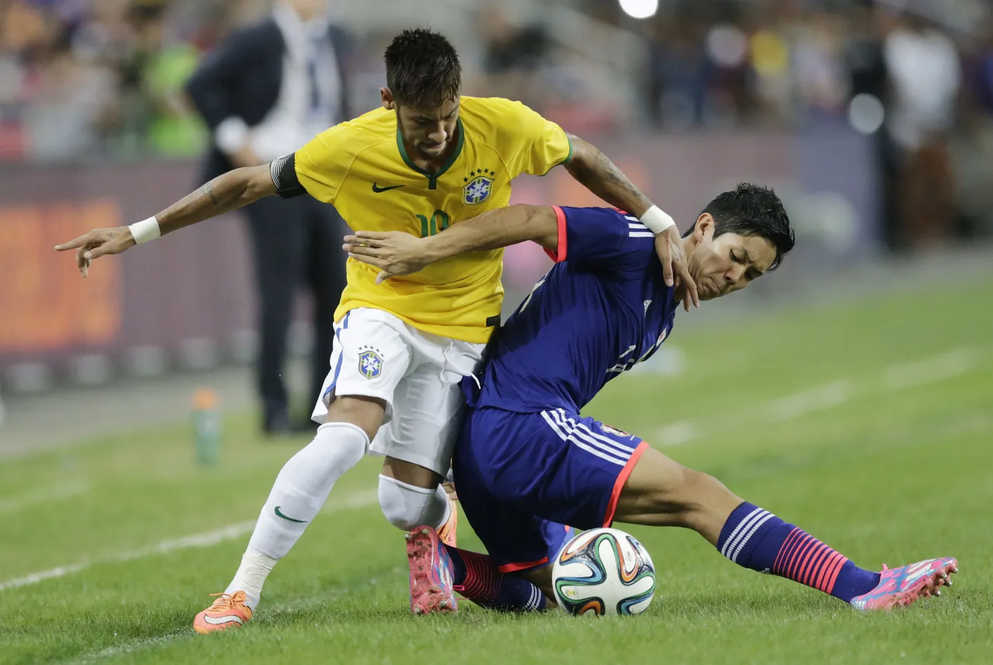 Yoshinori Muto (paremal) Jaapani koondise särgis heitlemas Brasiilia superstaari Neymariga.
