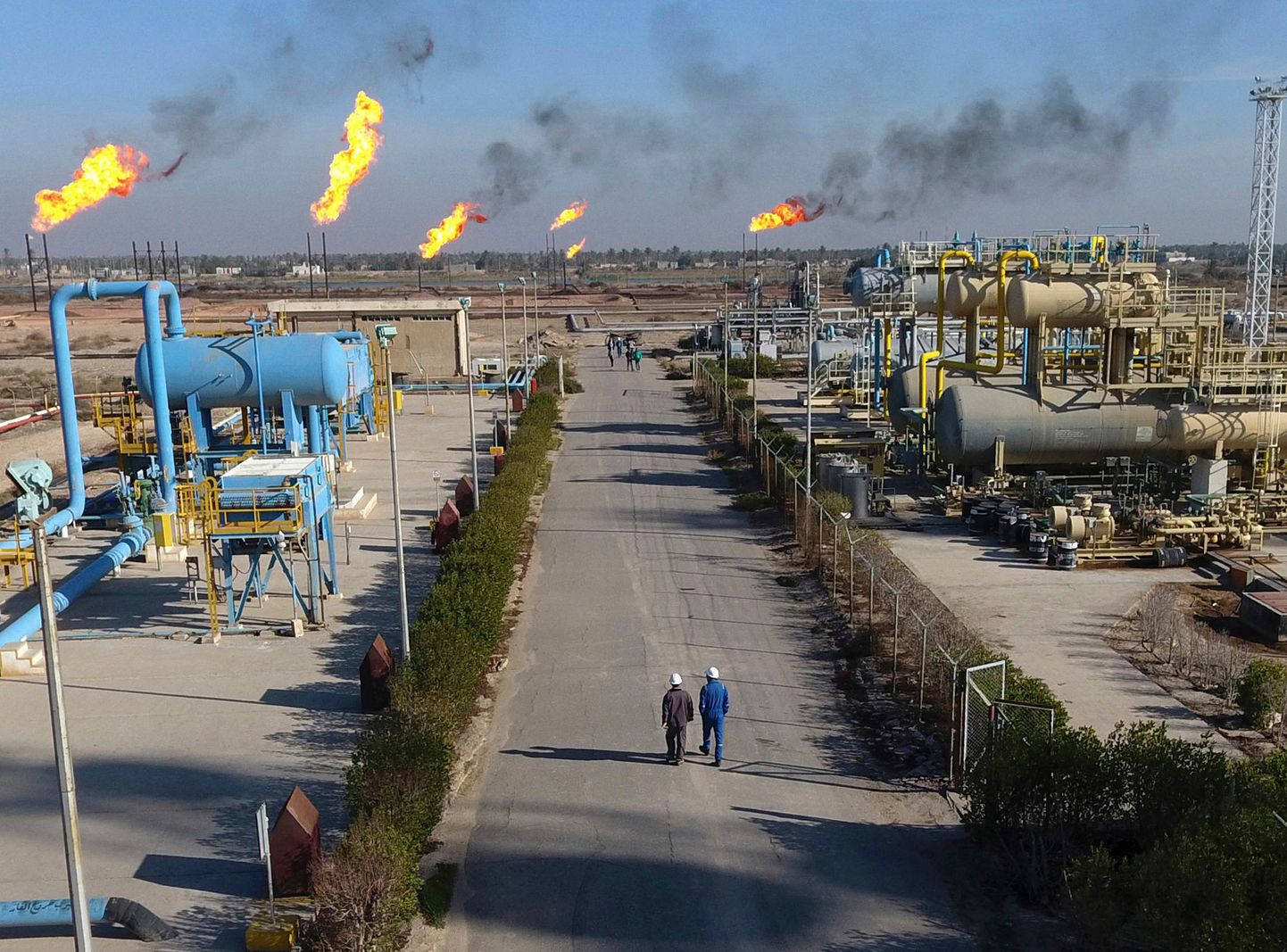 Töölised kõnnivad Iraagis Basra lähistel asuval Nihran Bin Omari naftamaardlal.