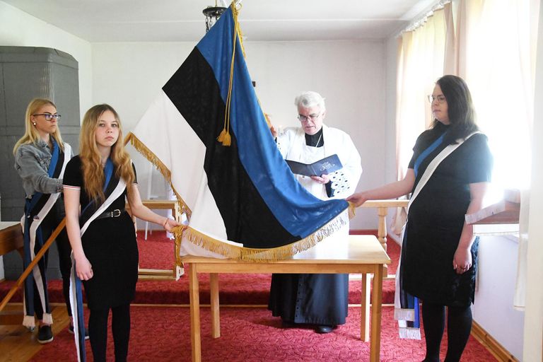 Õnnistamise ajal hoidis lippu seltsi liige Chätlyn Parts, keda assisteerisid seltsi noored toetajaliikmed Kaisa Hartwich ja Lisette Kivimägi.