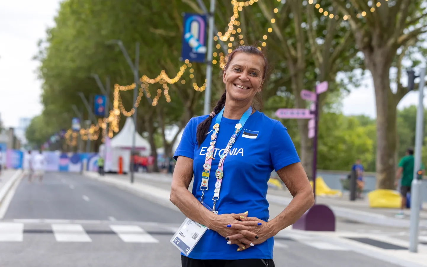 Helen Nelis-Naukas Pariisi olümpiakülas. Ta jõudis pärast nelja aastakümmet treenerina rassimist lõpuks olümpiale ning tema õpilane Nelli Differt saavutas Pariisis Eesti sportlaste parima koha.