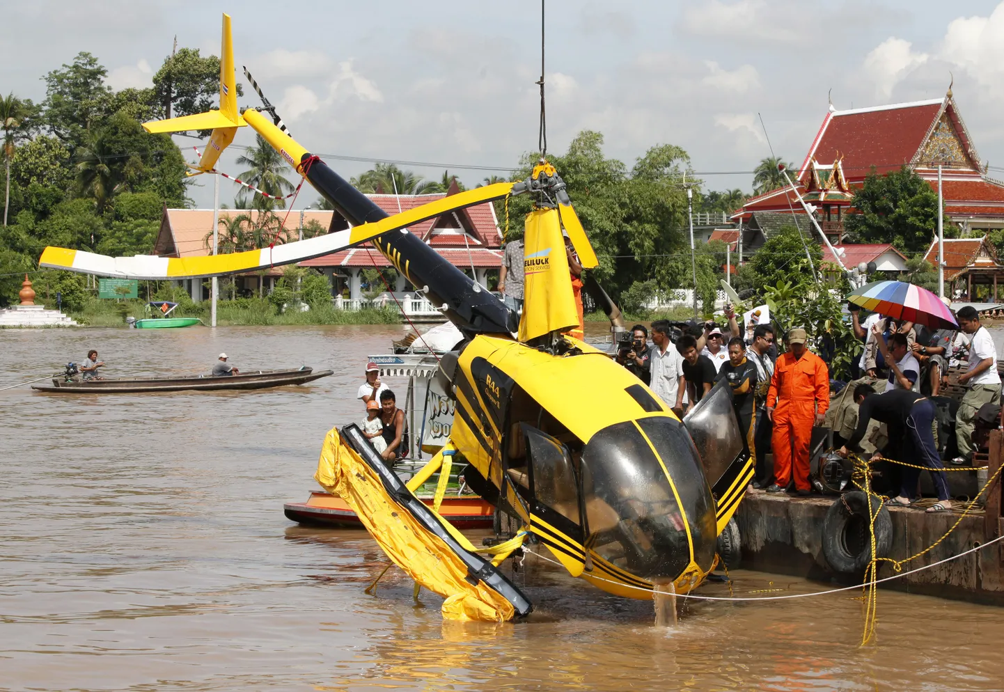 Päästetöötajad tõsstavad avariilist Robinson R44 kergkopterit Chao Phraya jõest Wat Klang Pak Kreti templi kai peale Nonthaburi provintsis Bangkoki äärelinnas. 12. septembril 2010. kukkus ajakirjanikke vedanud kopter jõkke olles eelnevalt takerdunud elektriliini kukkudes esmalt kaile ja siis uppus. Kaks ajakirjanikku ja mõlemad piloodid ujusid välja ja pääsesid vigastusteta.  REUTERS/Chaiwat Subpransom