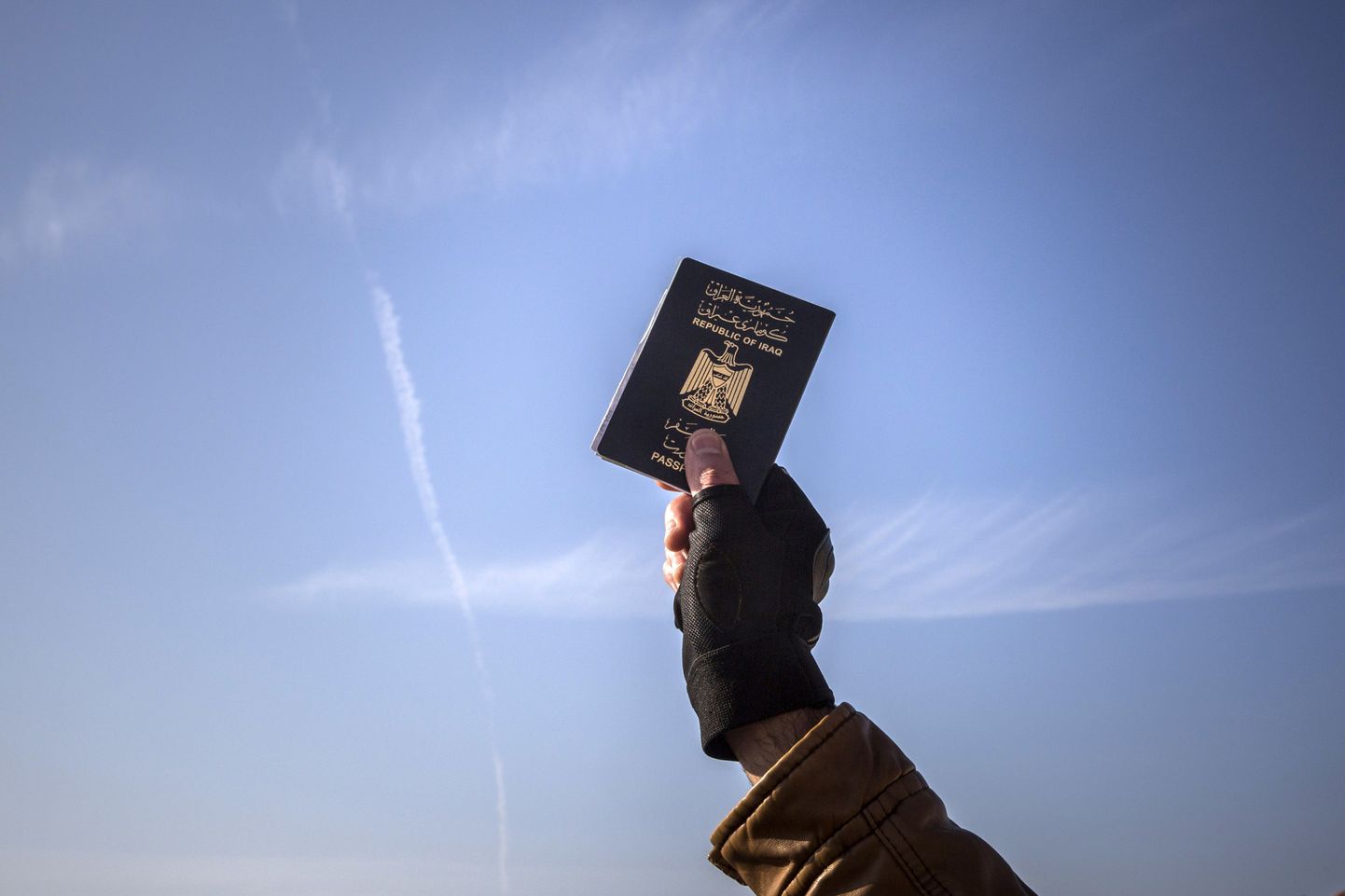 Põgenik hoiab käes iraagi passi.