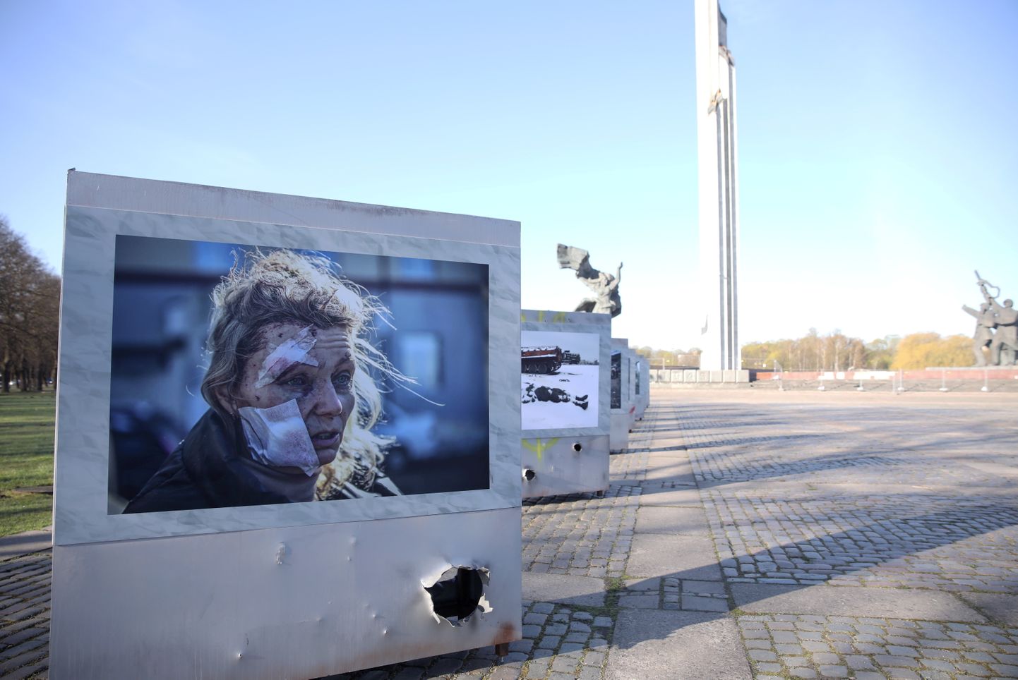 Выставка фотографий о войне в Украине у памятника в Пардаугаве