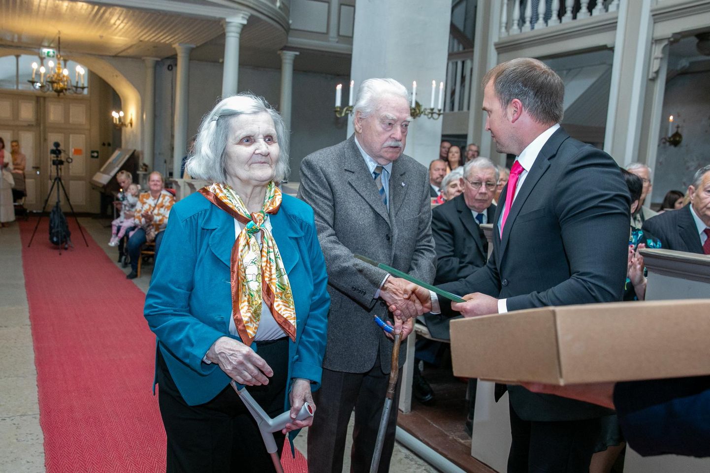 65 aastat abielus olnud Silvi ja Taavi Teinbast õnnitleb Rakvere Kolm­ainu kirikus toimunud kuldpulmapaaride austamisürituse üks korraldaja, Lääne-Viru Omavalitsuste Liidu tegevdirektor Sven Hõbemägi.