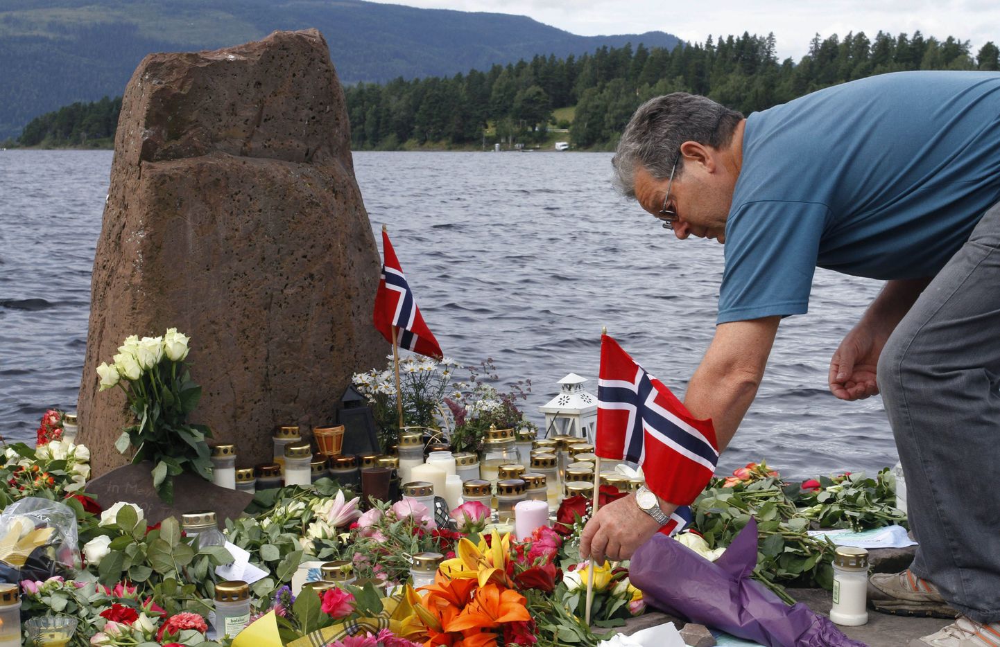 Utøya saare vastu jääva Utvika randa toodud lilled, küünlad ja lipud hukkunute mälestuseks