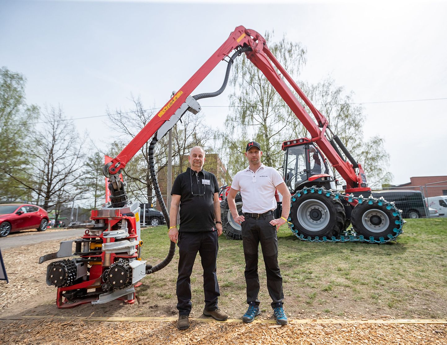 Toomas Jürgen (vasakul) ning Nisula müügi- ja turundusjuht Kalle Mattsson pidasid ettevõtte eksponaatidest üheks põnevamaks masinaks uut kuuerattalist N5 harvesteri.