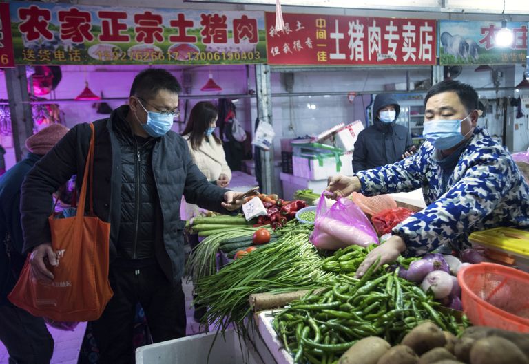 Inimesed Wuhani turul köögivilju ostmas.