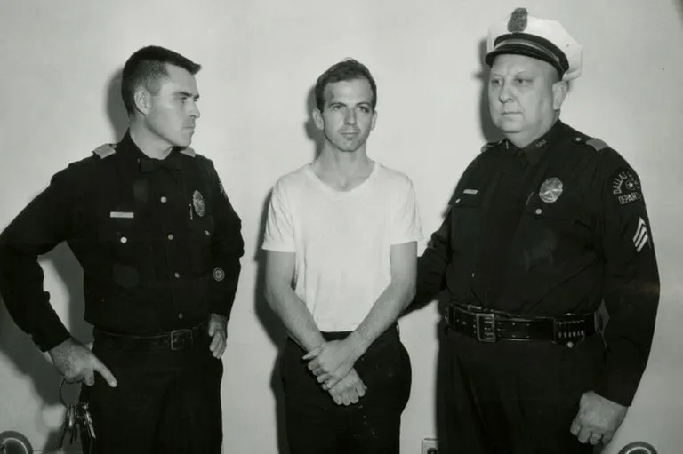 Ли Харви Освальд (в центре) был убит в подвале полицейского управления Далласа через два дня после ареста