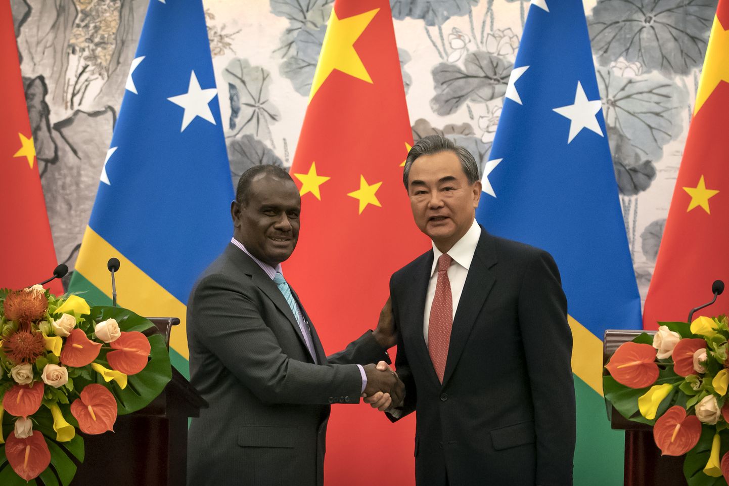 Hiina välisminister Wang Yi (paremal) ja Saalomoni saarte välisminister Jeremiah Manele laupäeval Pekingis kahe riigi diplomaatiliste suhete sõlmimise tseremoonial.