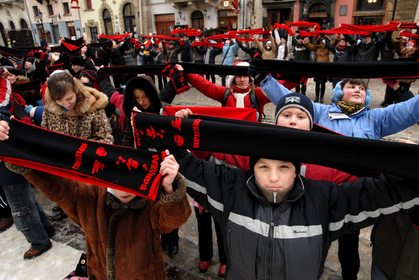 Юные сторонники Бандеры держат в руках шарфики с его изображением.
