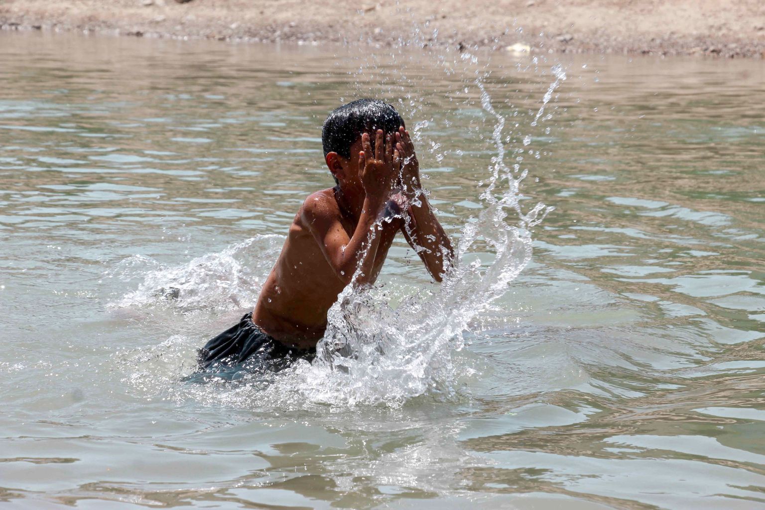 Afganistaani poiss end 21. juunil pea 40-kraadises kuumuses vees jahutamas.