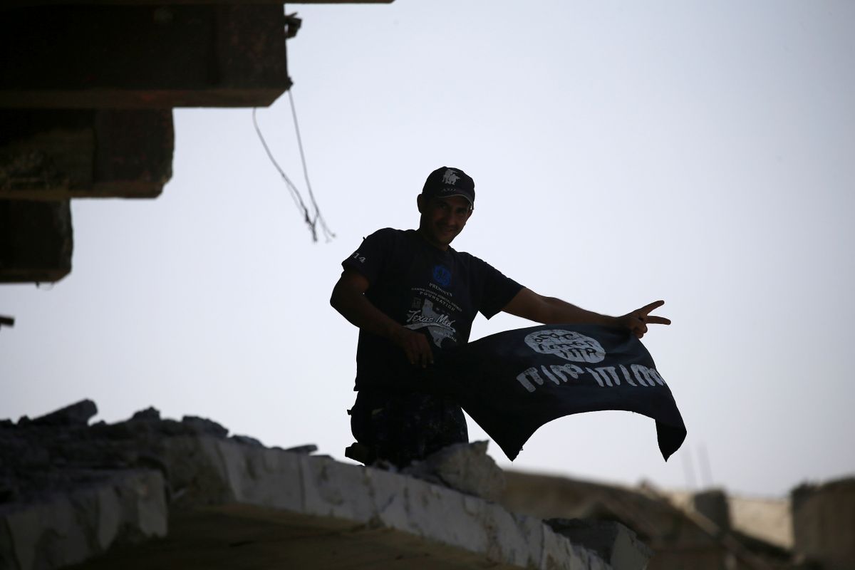 Irākas Drošības spēku cīnītājs tur rokās "Islāma valsts" karogu pēc Mosulas pilsētas atbrīvošanas