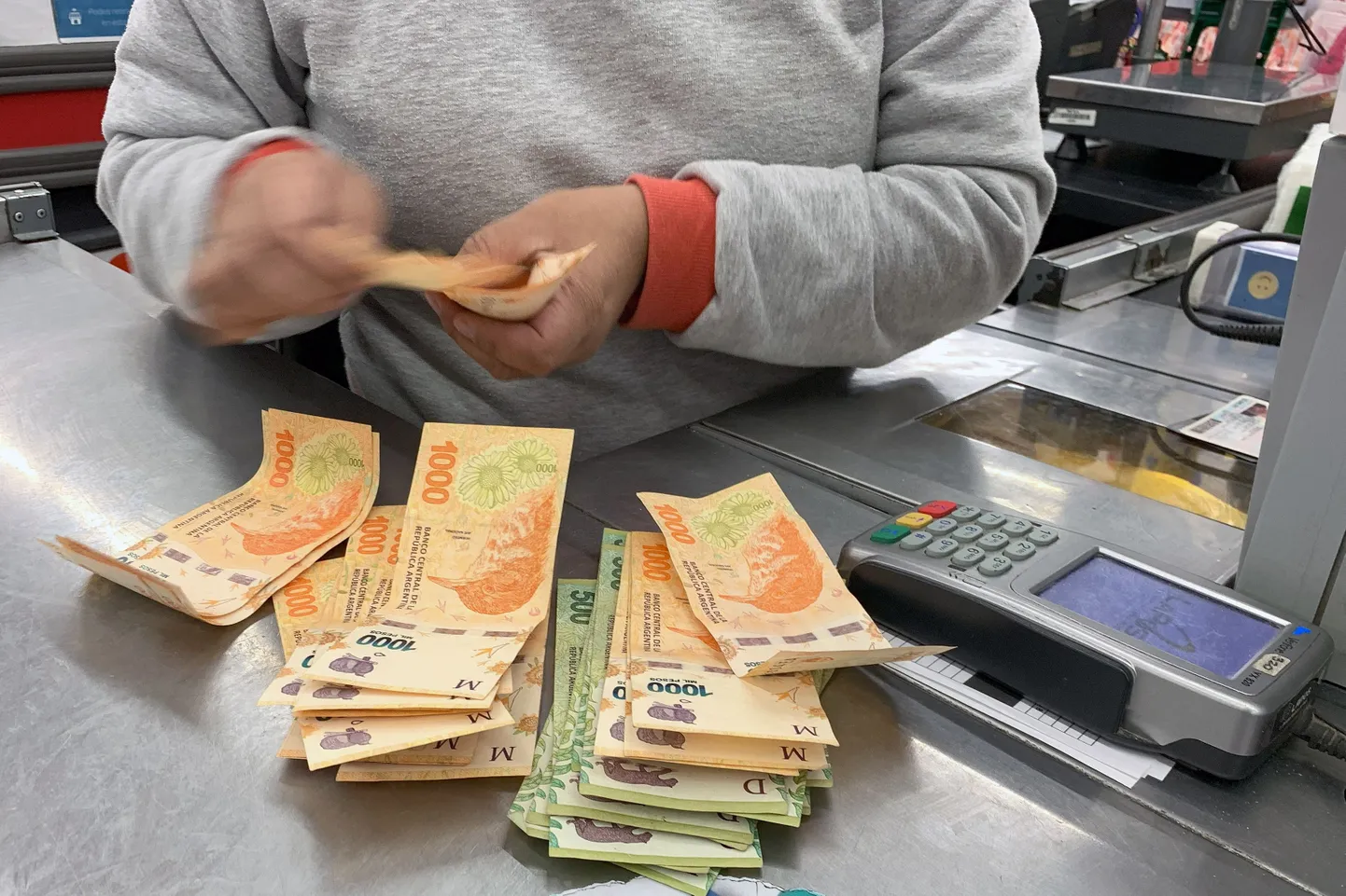 Kassapidaja loeb Argentina peesosid Buenos Airese kaubandukeskuses. Foto on illustratiivne.