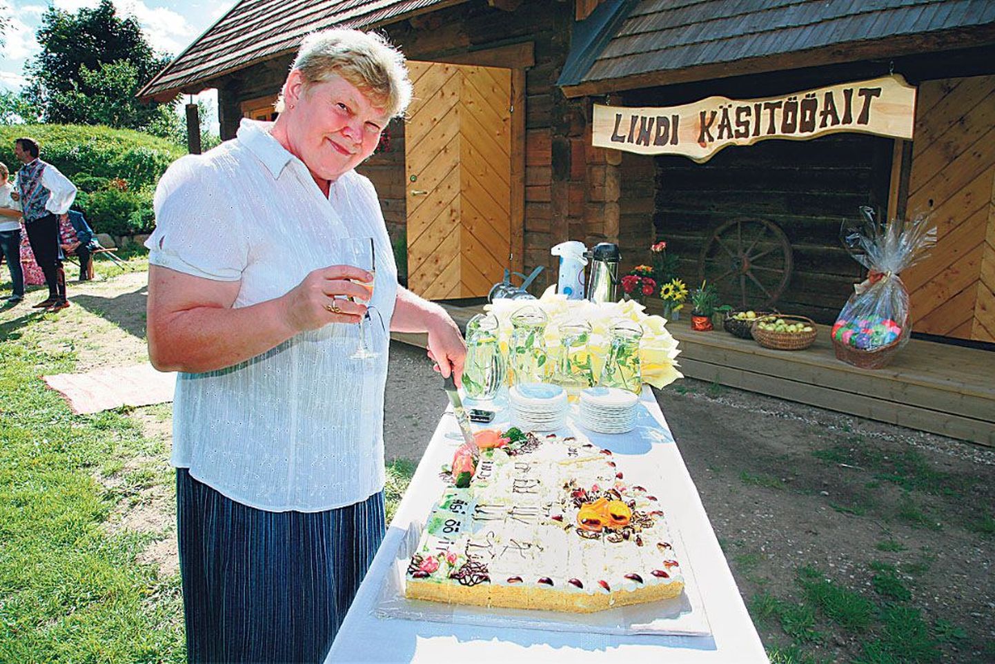 Lindil kodutalu õuel renoveeritud aida kui külarahva kasutusse mineva käsitööaida avamisel pakkus ettevõtmise eestvedaja ja projektikirjutaja Tiiu Sommer torti.