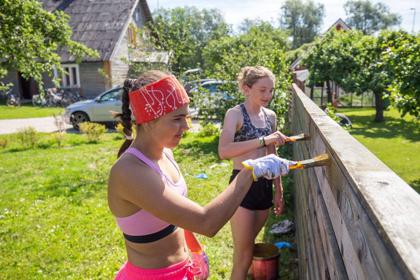 Türi õpilasmaleva noored Karolin Surva (esiplaanil) ja Hannah Kaljur värvivad kogukonnakeskuses planku.