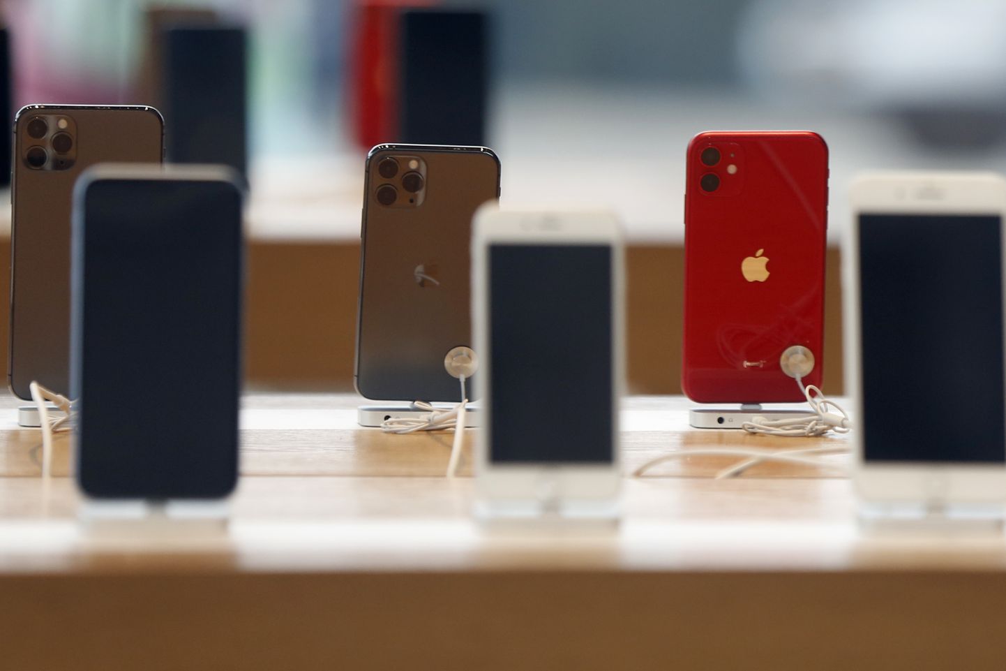 Rows of iPhones are displayed Saturday, March 14, 2020, inside a closed Apple store in downtown Brooklyn in New York. Apple CEO Tim Cook announced the tech giant would close all Apple retail stores outside of China to help stem the global spread of the coronavirus. (AP Photo/Kathy Willens)