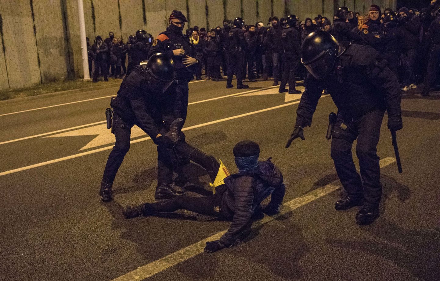 Policija aiztur protestētāju, kurš bloķē ceļu Barselonā. 