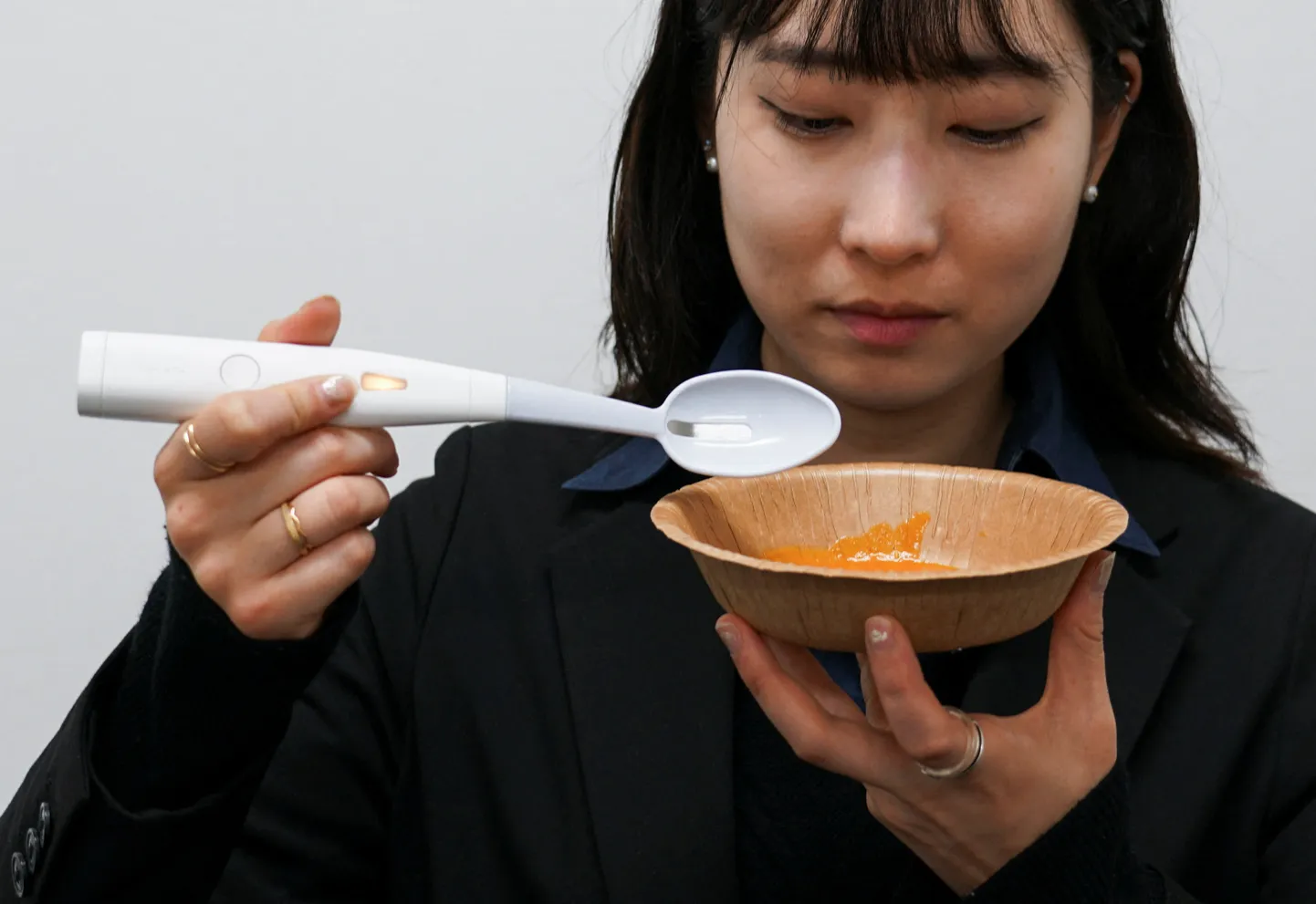 Kirin Holdingsi töötaja demonstreerib Meiji ülikoolis välja töötatud elektrilist lusikat, mis suudab suurendada toidu soolast maitset, 20. mai 2024 Tokyo.