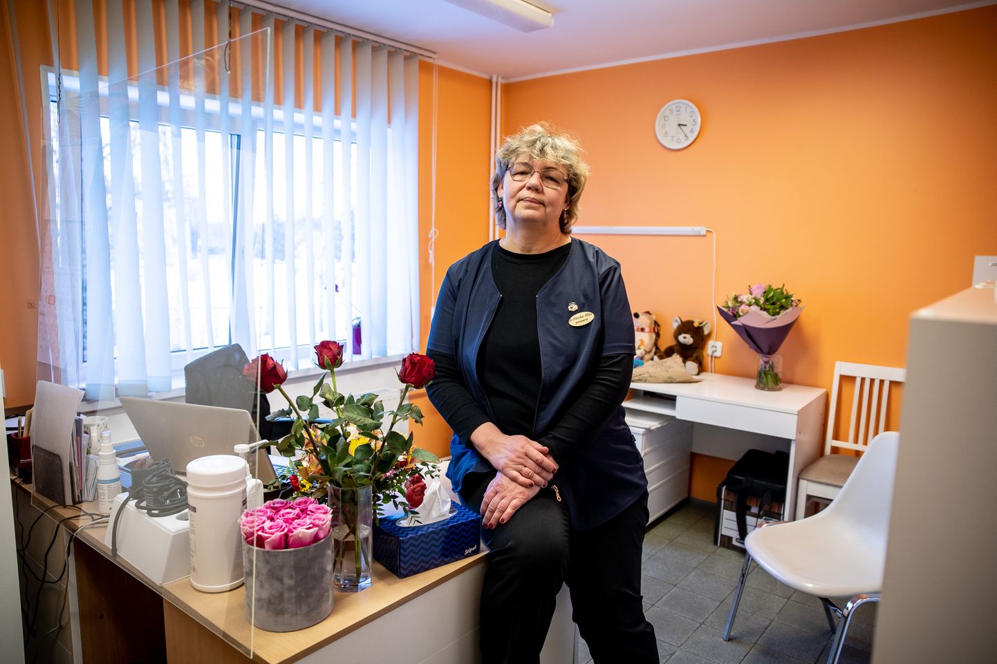 Perearst Viivika Allas oma kabinetis, mida ehivad mitmed lillekimbud.