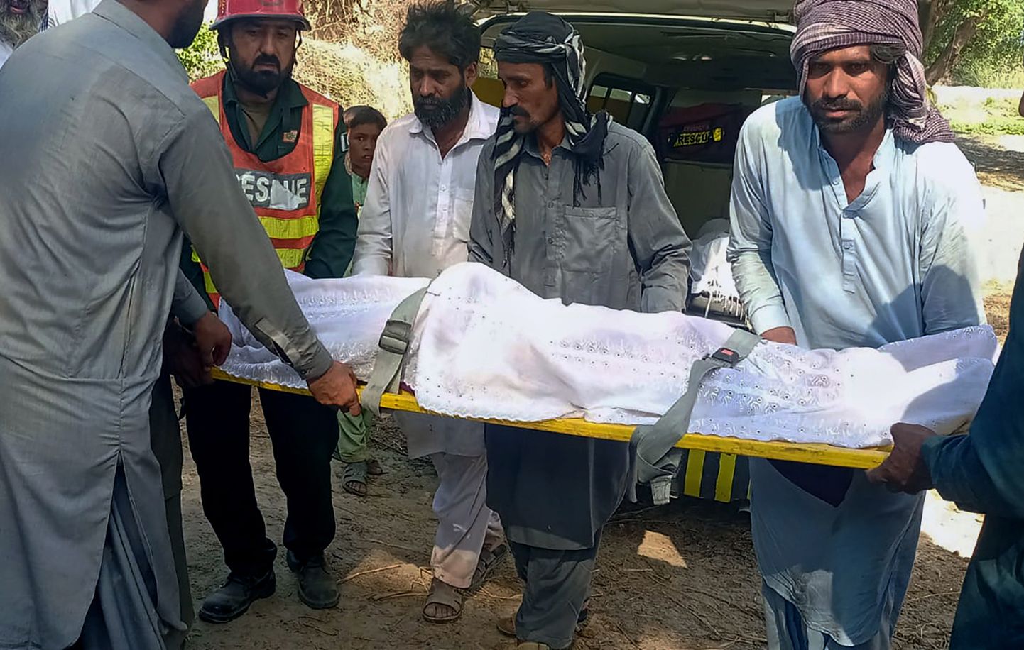 Päästetöötaja ja külaelanikud kannavad Induse jõel toimunud paadiõnnetuse ohvri surnukeha
