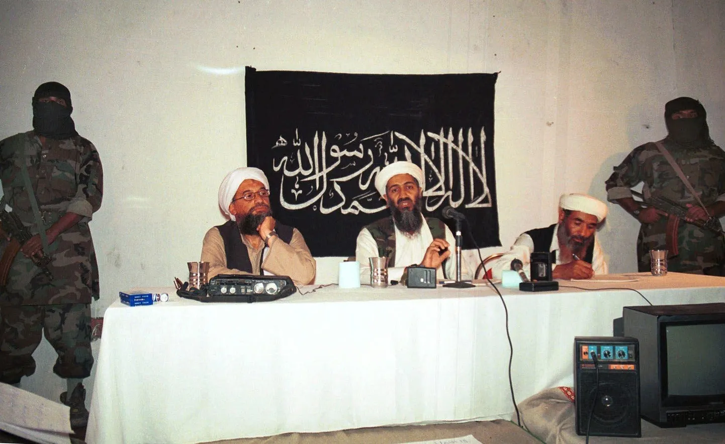 Al-Qaeda praegune juht Ayman al-Zawahri (laua ääres vasakul) ja toonane liider Osama bin Laden (keskel) peavad 1998. aastal Afganistanis pressikonverentsi.
