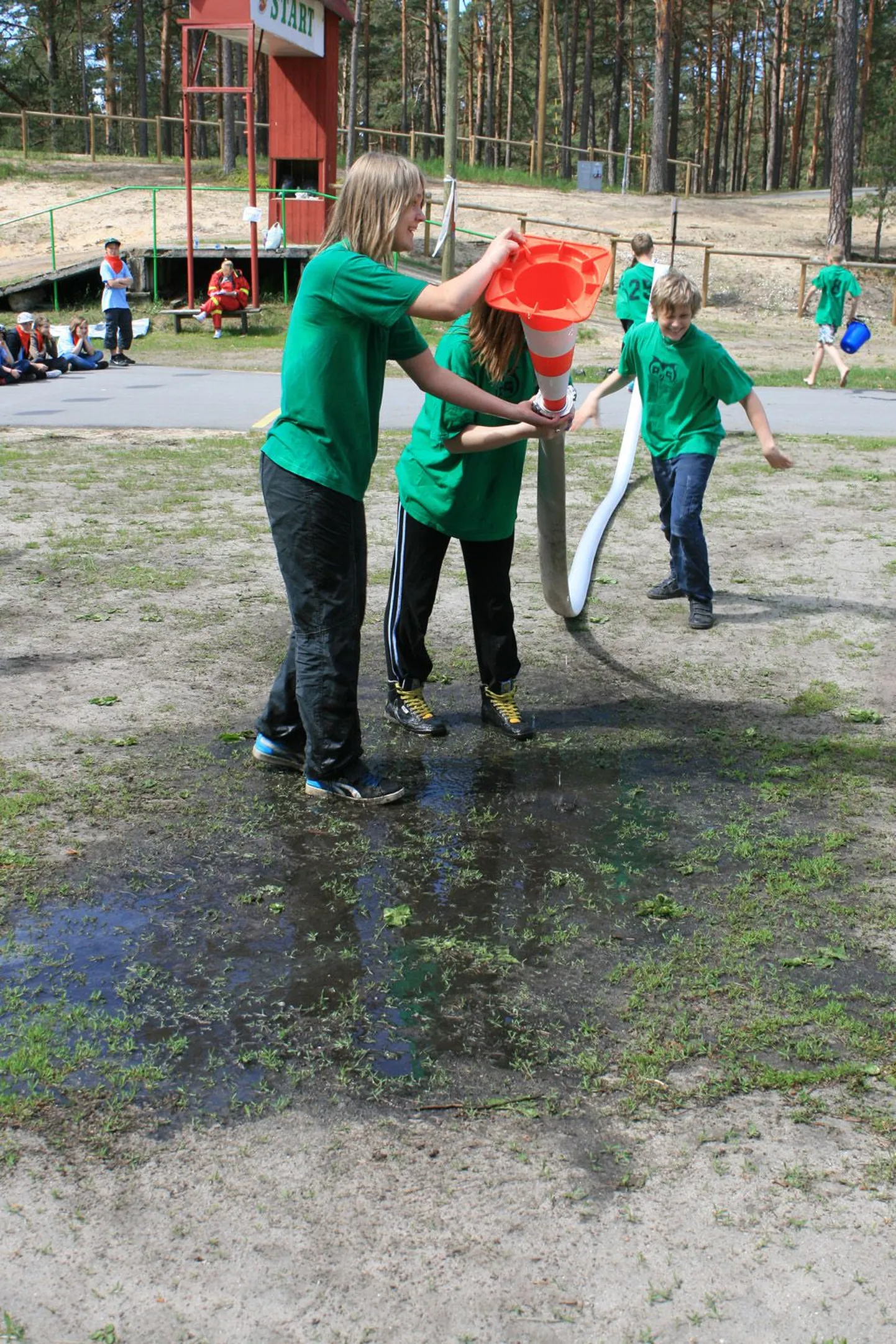 Pärnu-Jaagupi gümnaasiumi õpilased ajavad läbi vooliku vett ühest ämbrist teise.