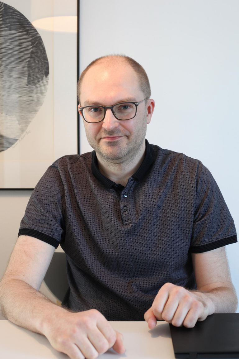 Programmeerija Kristjan Kelt oma kodus Luksemburgis laste õppematerjalidest tühjaks tõstetud köögilaua taga.